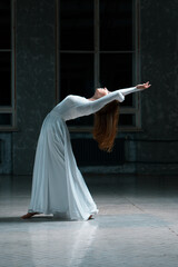 Fototapeta na wymiar girl bends back in a long white dress, ballroom costume on a dancer.