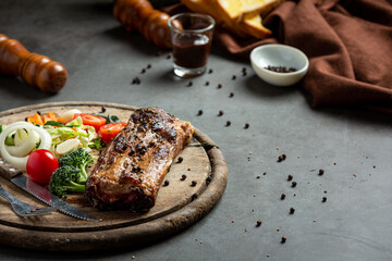 Roasted pork steak and vegetables on wooden cutting board