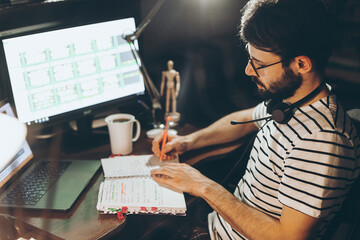 adult bearded man working sitting at home desk at computer, working online. Self-isolation during quarantine, work at home, copy space