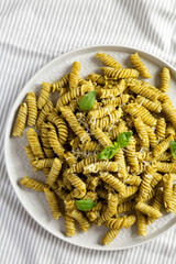 Homemade Pesto Twist Pasta on a plate on cloth, top view. Overhead, from above, flat lay. Close-up.