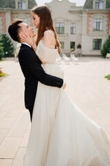 beautiful newlyweds dancing and whirling against the background of a building. 