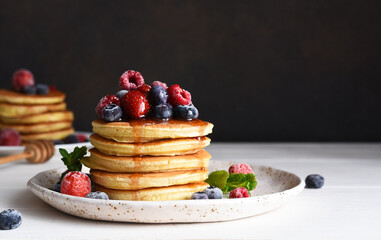 Pancakes with berries and maple syrup for breakfast