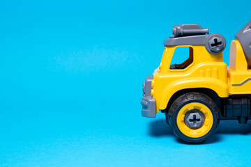 Plastic truck on a blue background with copy space for text. Children's toy