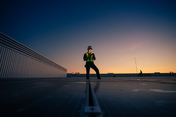 Asian man engineer service check installation solar cell on the roof of factory on the morning.