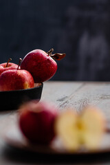 Fresh red apples on a plate on a wooden background. Red apples on a dark background. Selective focus