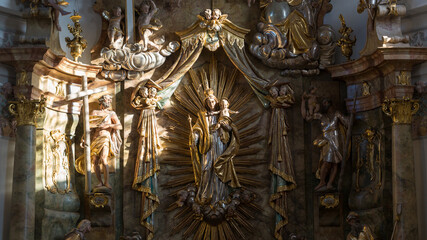 Fototapeta na wymiar Religious sculptures illuminated by a sunray. With mary and her child Jesus. Inside the church St. Alto und St. Birgitta.