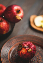 Fresh red apples on a plate on a wooden background. Red apples on a dark background. Selective focus