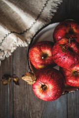 Fresh red apples on a plate on a wooden background. Red apples on a dark background. Selective focus