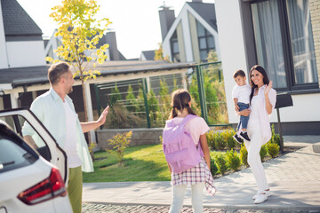 Photo portrait of father bringing girl coming back from school exiting white car saying hi hello outdoors on street in summer