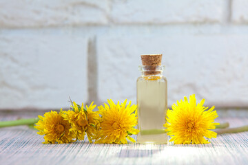 dandelion essential oil in  beautiful bottle on table © solstizia