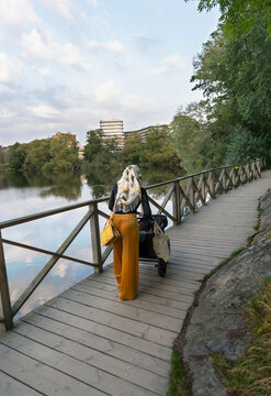 Woman pushing pram at lake