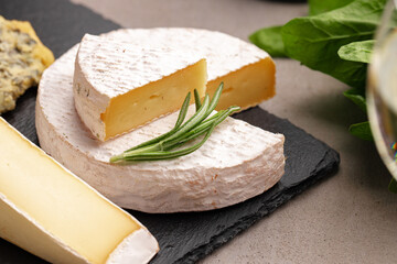 Several different pieces of cheese served on black stone flat plate