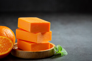 Orange soap with fresh orange on dark background