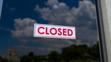 Closed Sign on Shop Window. Store sign. Close-up on a closed sign in the window of a shop displaying the message. The glass reflects the day city and the sky. 3d rendering