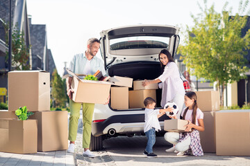 Full size photo of smiling happy family move pack stuff mom dad watch little boy give football ball...