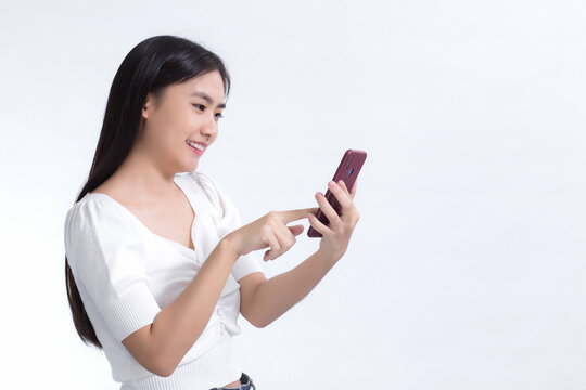 Portrait of beautiful asian girl Use the mobile phone happily on a white background