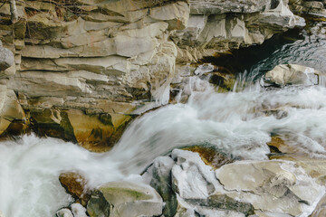 Winter mountain stream among rocks and stones