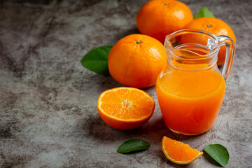 Fresh orange juice in the glass on dark background