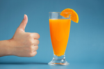 Fresh orange juice in the glass on blue background