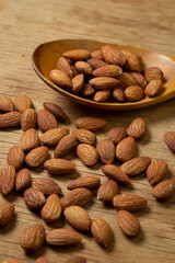 Almonds on a wooden background. Isolated almonds. Roasted almonds in a wooden spoon