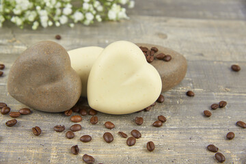 Fototapeta na wymiar Fragrant natural handmade soap in the shape of a heart and coffee beans on a countertop.