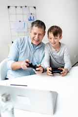 Family and childhood concept. Dad and son have fun together while they play a computer game.