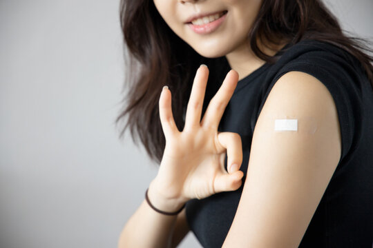 Healthy asian woman getting vaccinated immunity giving ok hand sign to rolling out vaccine, concept of recommended inoculation, vaccination, vaccinated patient, vaccine roll-out program