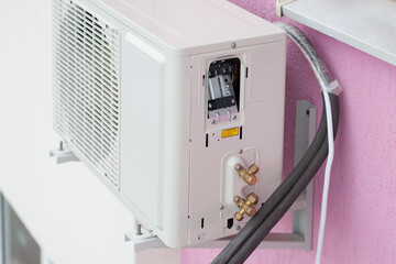 The outdoor air conditioner unit on brackets and insulated copper tubes for its connection.