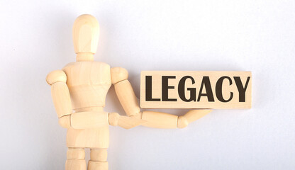 Wooden man shows with a hand to block with text LEGACY