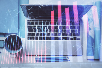 Double exposure of forex graph drawing over desktop background with computer. Concept of financial analysis. Top view.