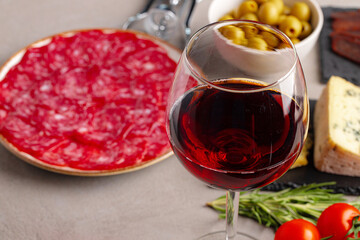 Meat slicing and wine on gray background