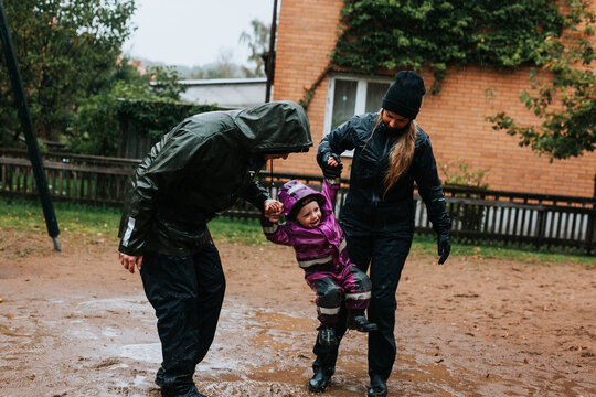 Parents Swinging Toddler Girl