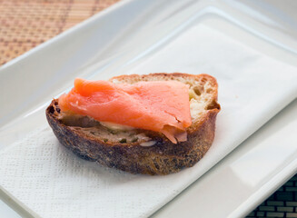 delicious canapes of salted, smoked salmon fillet on slice of fresh ciabatta bread