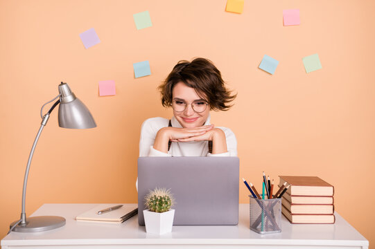 Photo of optimistic nice short hairdo girl sit look laptop wear pullover isolated on peach color background