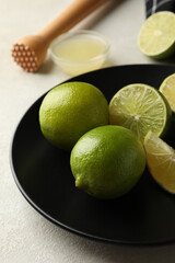 Concept of healthy food with ripe limes on white textured background