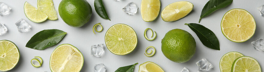 Fresh ripe limes, ice and leaves on whole background
