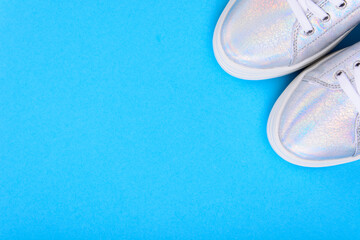 Silver sneakers on a blue background with place for text