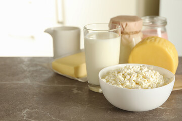 Different fresh dairy products on gray table, space for text