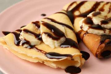 Plate of crepes with chocolate sauce and banana slices