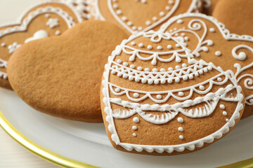 Tasty heart shaped gingerbread cookies in plate, closeup