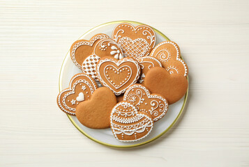 Tasty heart shaped gingerbread cookies on white wooden table, top view