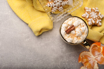 Flat lay composition with delicious marshmallow drink and yellow sweater on light grey table. Space for text