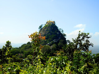 Obraz premium Bagan, Myanmar - november 2019: Famous buddhist temple on the summit of Taung Kalat volcano near Mt. Popa. 777 stairs have to be climbed barefoot along with monkeys to reach the top.