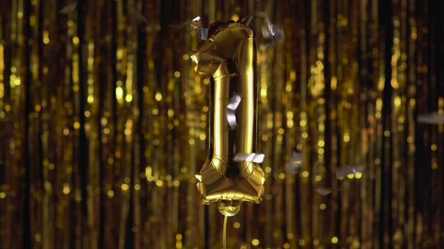 Gold foil number 1 one festive balloon on a yellow background. The concept of birthday, anniversary, date.