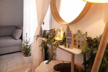 Wooden console table with Christmas decor near wall in room. Interior design