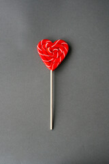 Red heart-lollipop on a gray background. Card for Valentine's day.