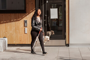 Visually impaired woman walking with guide dog