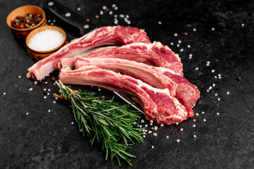 Raw lamb ribs with spices on a stone background