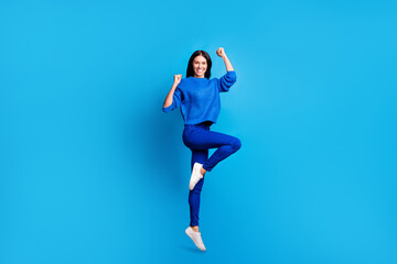 Fototapeta na wymiar Full size profile photo of brunette optimistic cute lady jump wear blue sweater trousers sneakers isolated on bright background