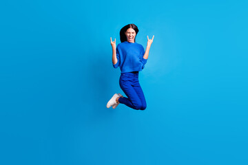 Obraz premium Full body photo of crazy funky woman jump up air make horned signs scream isolated on blue color background
